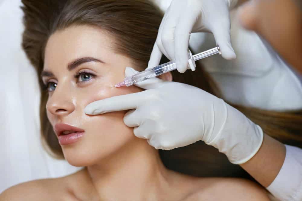 Provider performing a cheek filler treatment