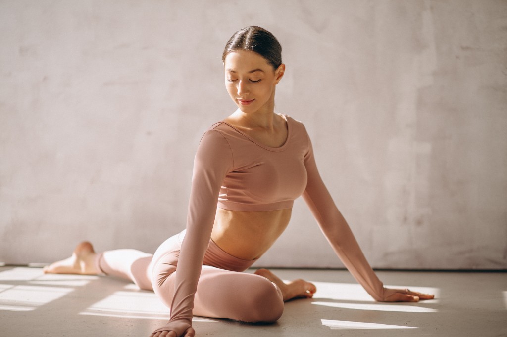 Woman stretching in soft wellness studio light